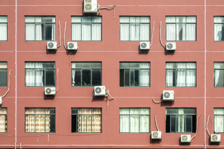 Call Tiger Services if you have A building wall with windows and outside air conditioning units in need of ac repair in San Antonio.